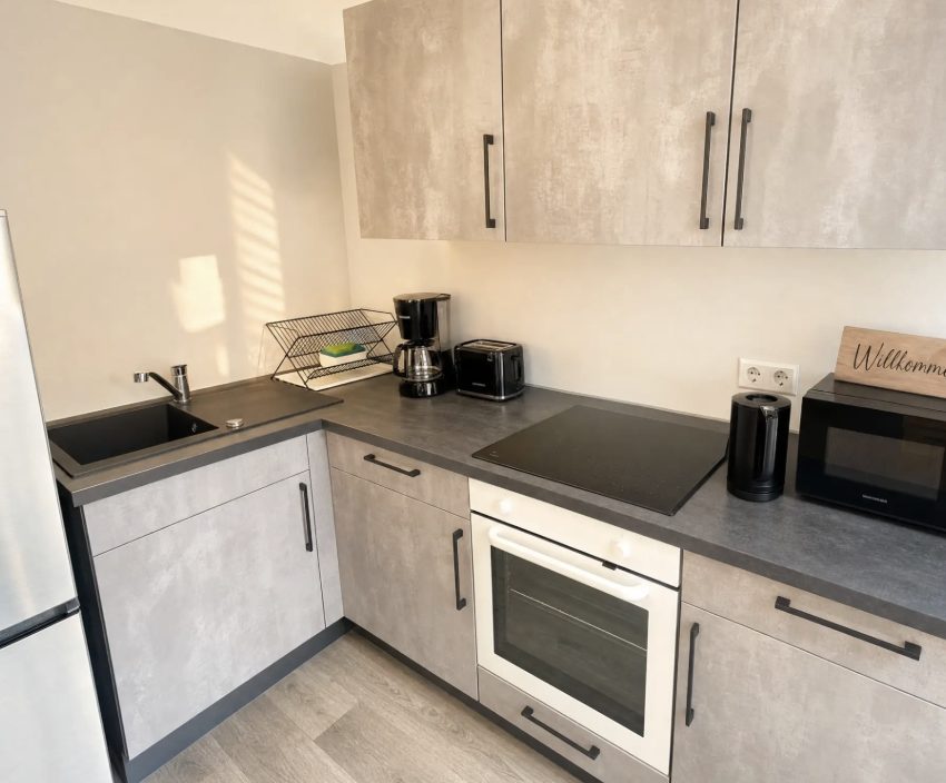 Küchenzeile der Monteurwohnung in Erfurt mit Kühlschrank, Ceranfeld und Backofen